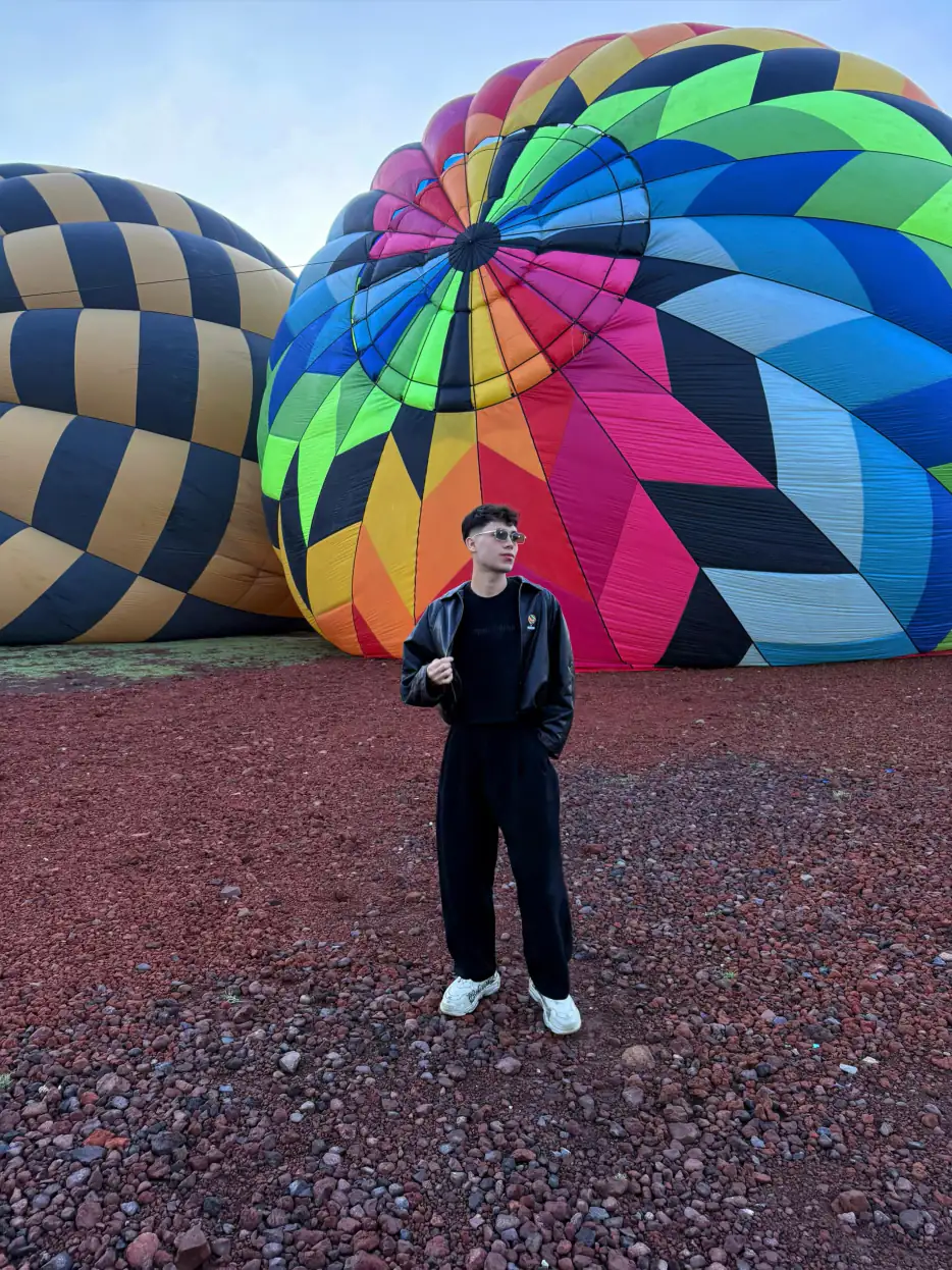 Hombre de pie frente a los globos ya inflados en el globopuerto de Volando en Globo en Teotihuacán