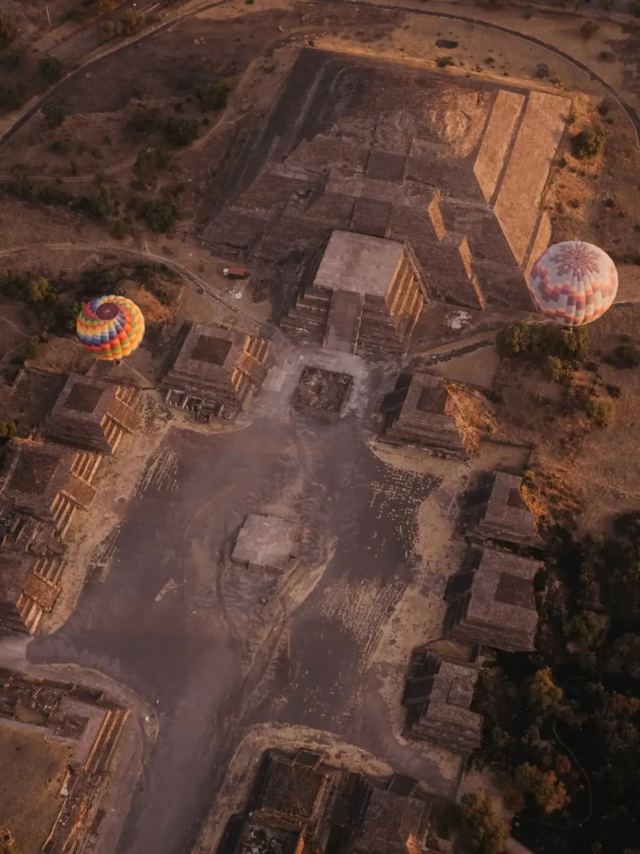 Vista aérea del conjunto de pirámides de Teotihuacán con globos aerostáticos al amanecer